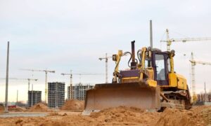 Bulldozer grading an active construction site where control points must be protected during construction staking