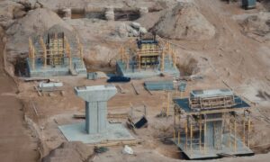 Construction site showing excavation work and concrete columns during foundation engineering