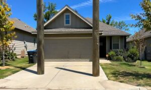 A residential property with utility poles blocking the driveway, showing how an ALTA title survey can reveal access issues