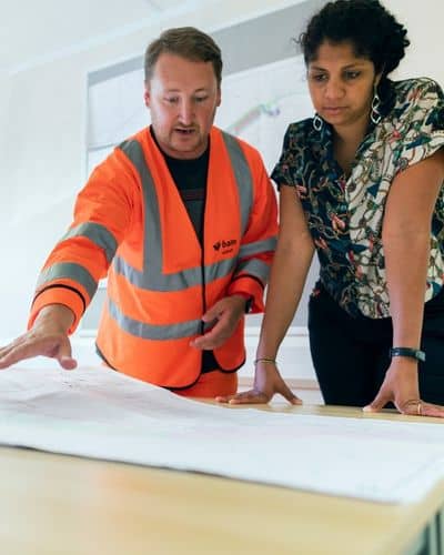 Engineers reviewing road design plans during early project planning