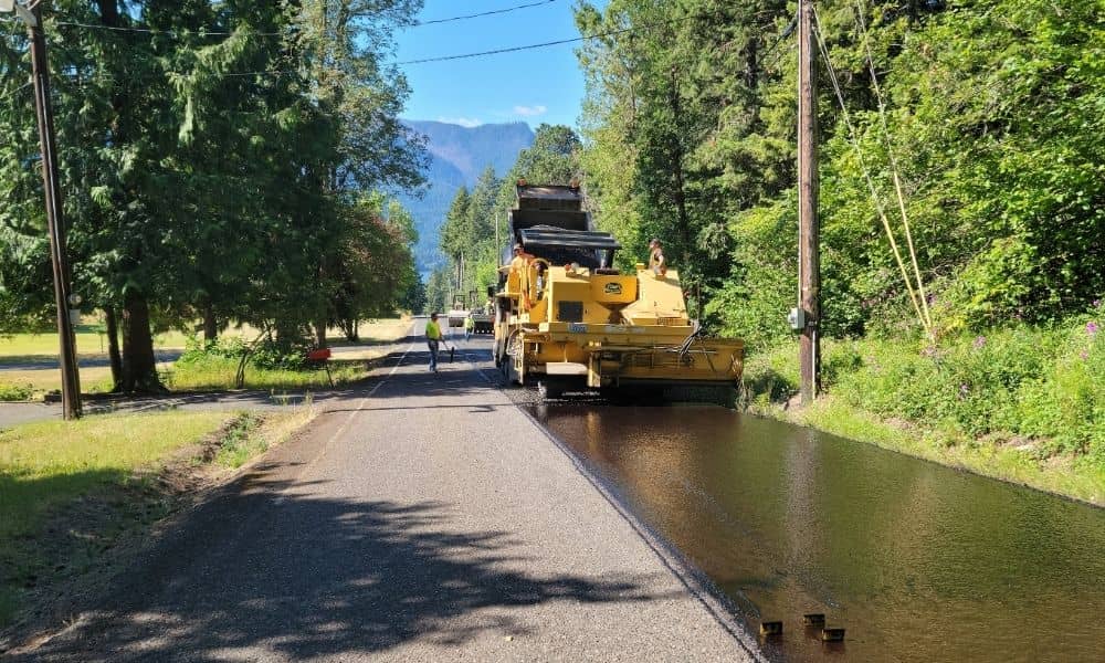 Road construction crew paving a rural road during active site work